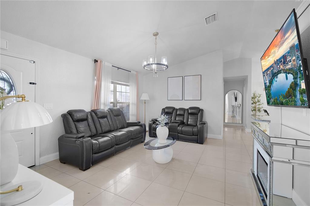16285 Southwest 21st Court Ocala, FL 34473 - Photo 5 of 40 a living room with furniture a chandelier and a flat screen tv
