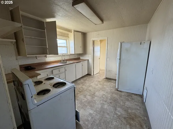 a kitchen that has a sink a stove and a refrigerator
