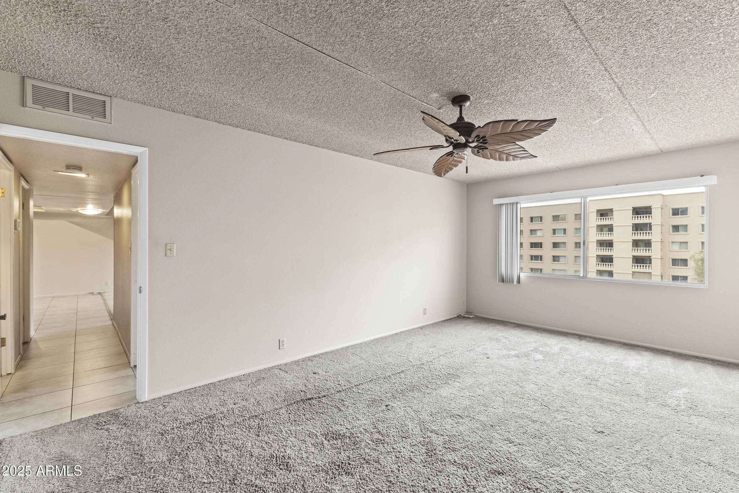 7920 East Camelback Road, Unit 303 Scottsdale, AZ 85251 - Photo 17 of 45 an empty room with fan and windows
