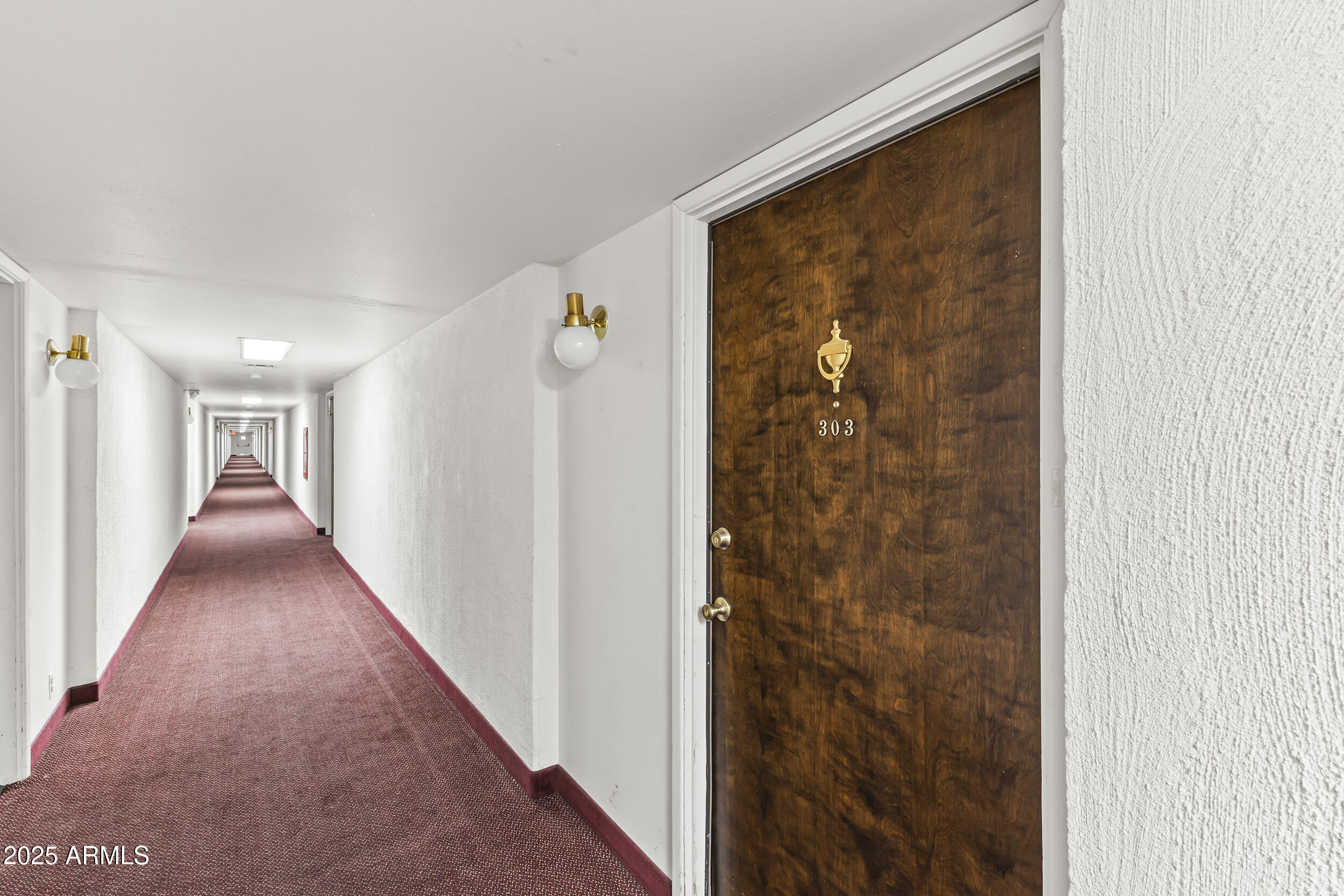 7920 East Camelback Road, Unit 303 Scottsdale, AZ 85251 - Photo 27 of 45 a view of a hallway with wooden floor and a bathroom