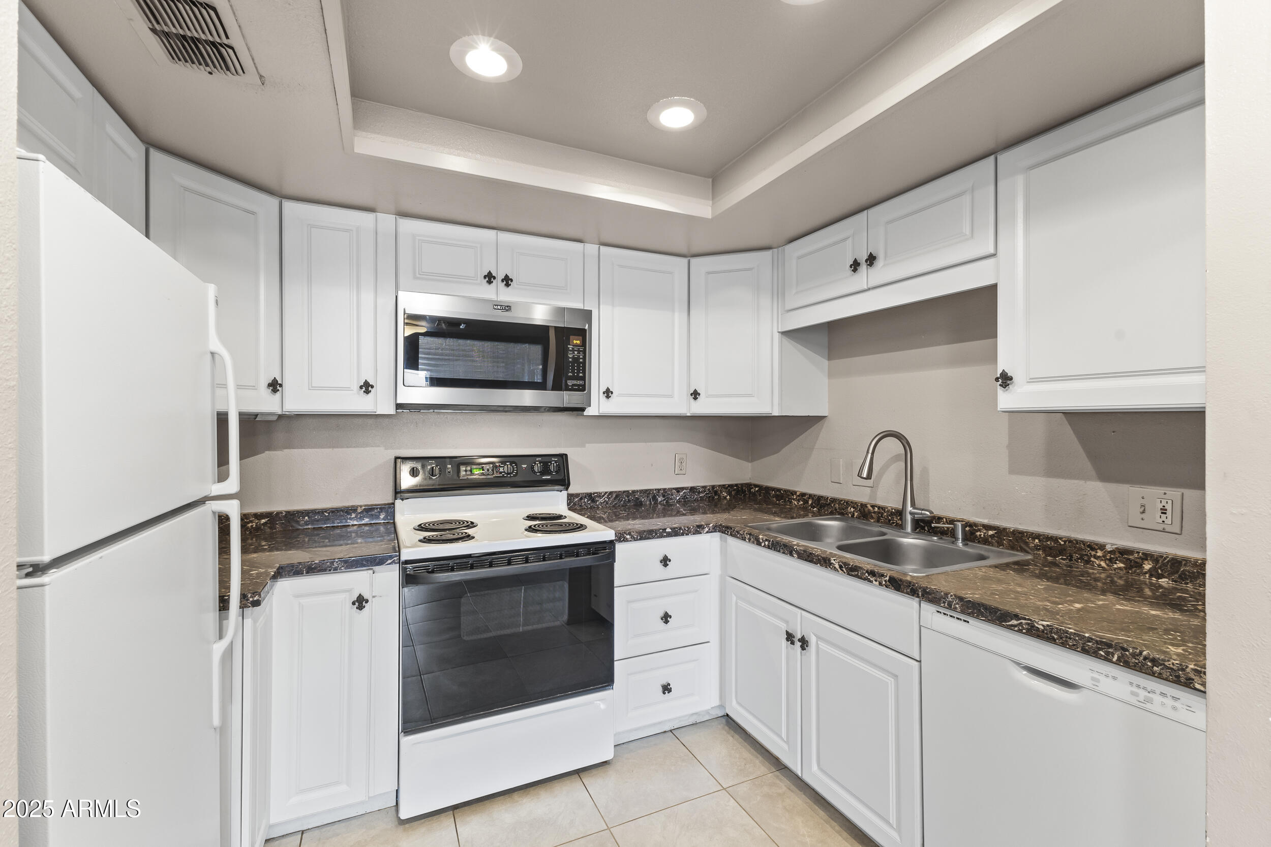 7920 East Camelback Road, Unit 303 Scottsdale, AZ 85251 - Photo 3 of 45 a kitchen with granite countertop white cabinets white stainless steel appliances and a sink