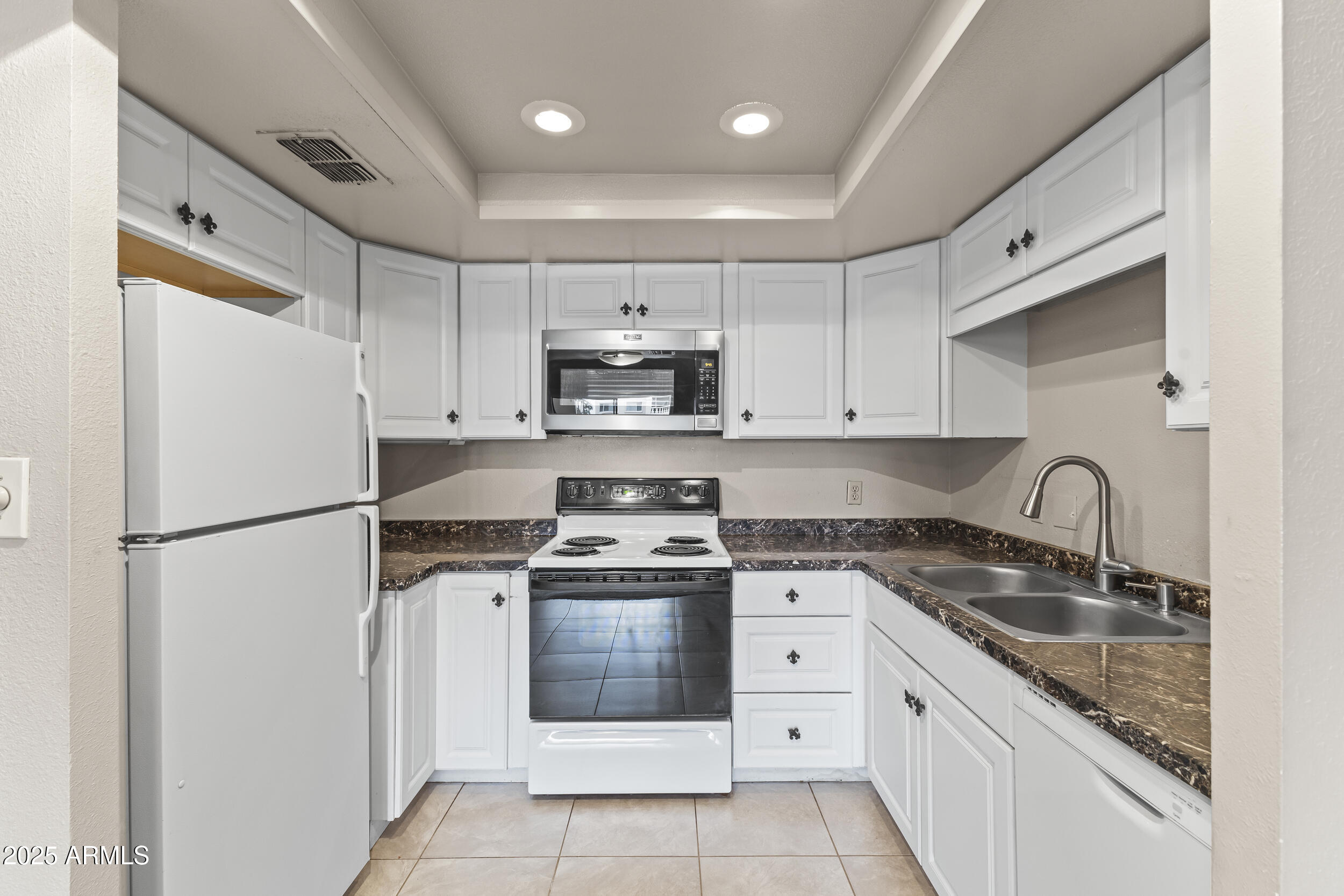 7920 East Camelback Road, Unit 303 Scottsdale, AZ 85251 - Photo 4 of 45 a kitchen with white cabinets sink and white stainless steel appliances