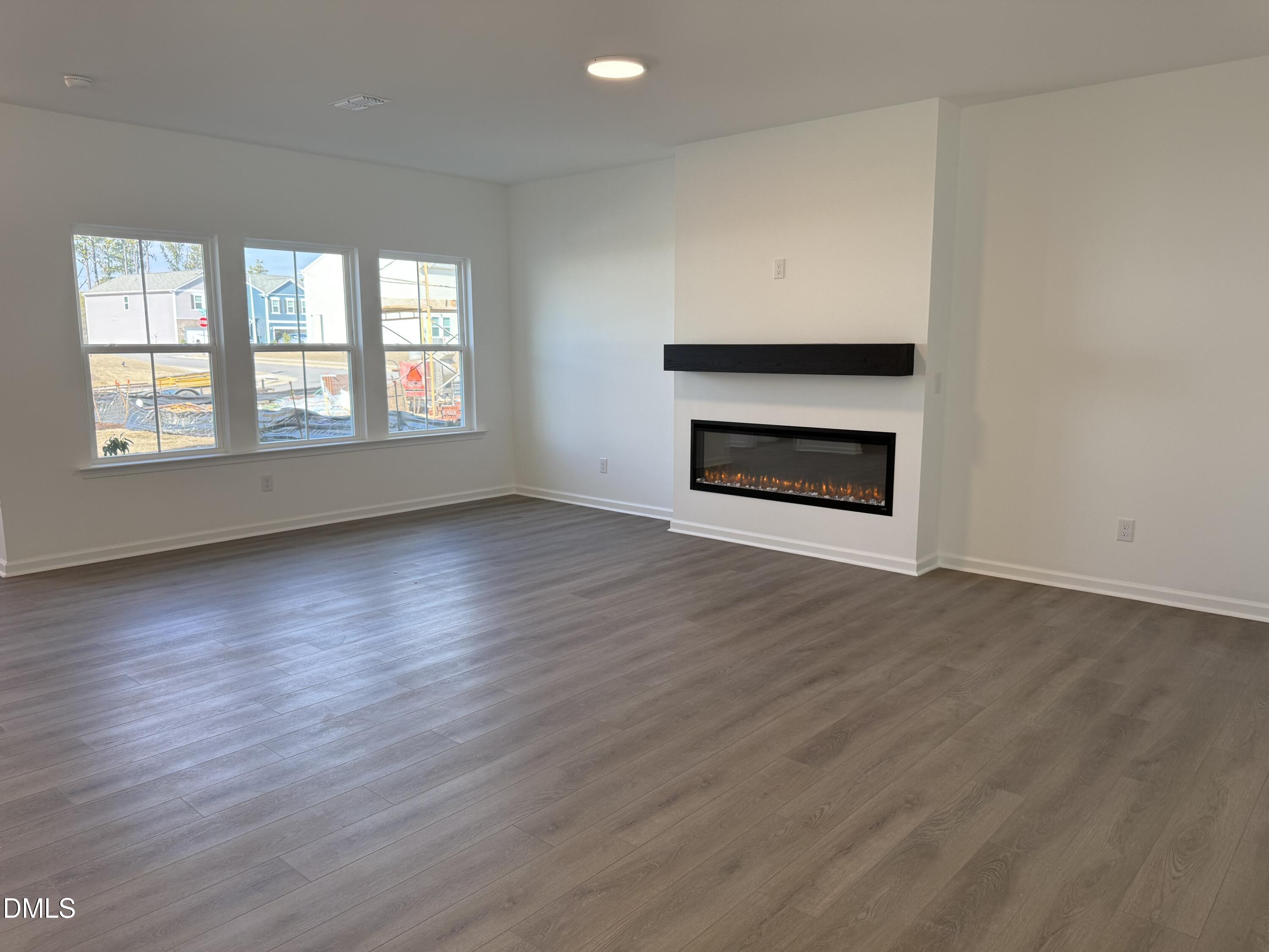 2840 Quarry Road, Unit 174 Rolesville, NC 27571 - Photo 3 of 30 an empty room with wooden floor fire place and windows