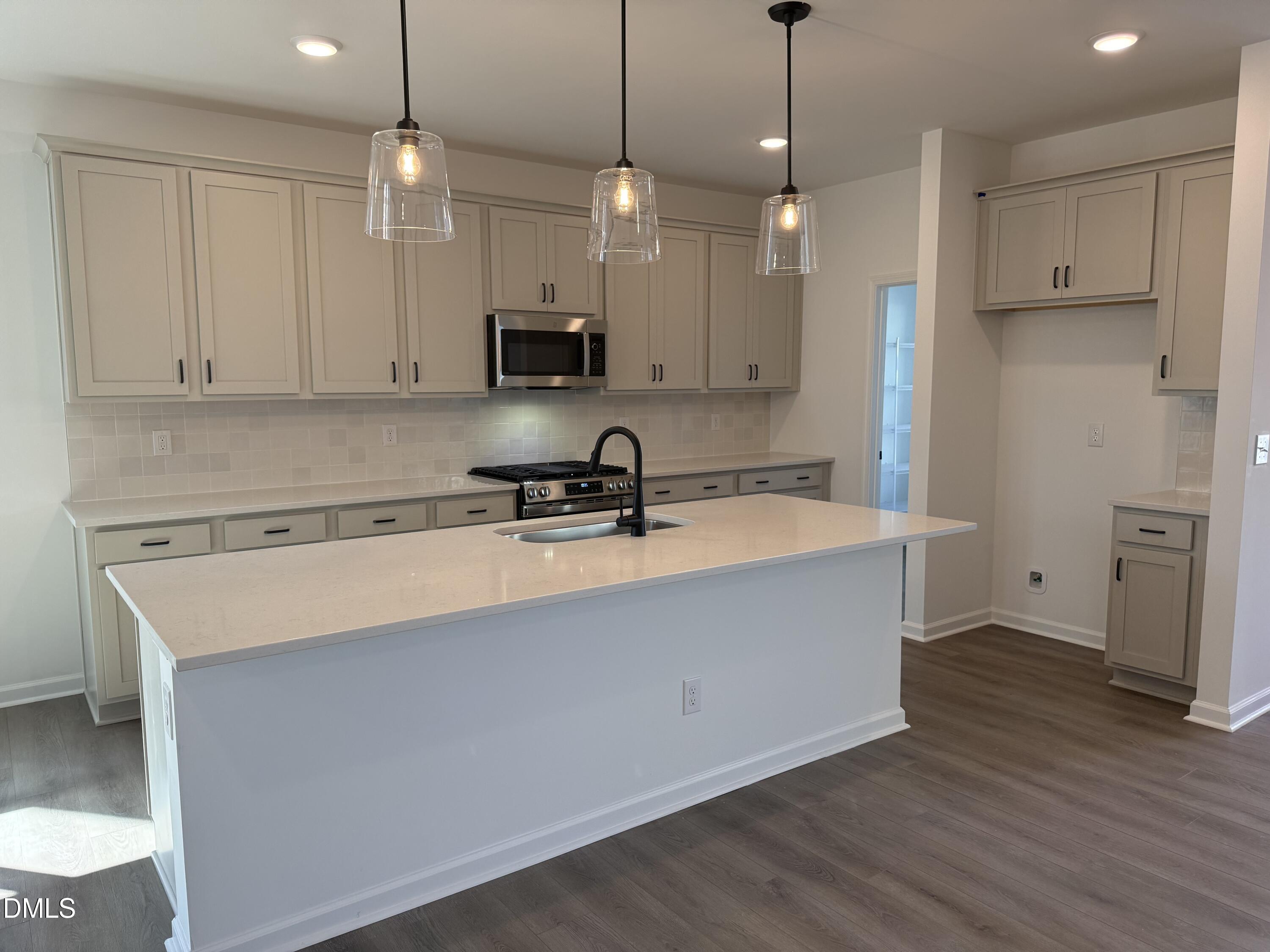 2840 Quarry Road, Unit 174 Rolesville, NC 27571 - Photo 4 of 30 a kitchen with kitchen island a sink stainless steel appliances and cabinets