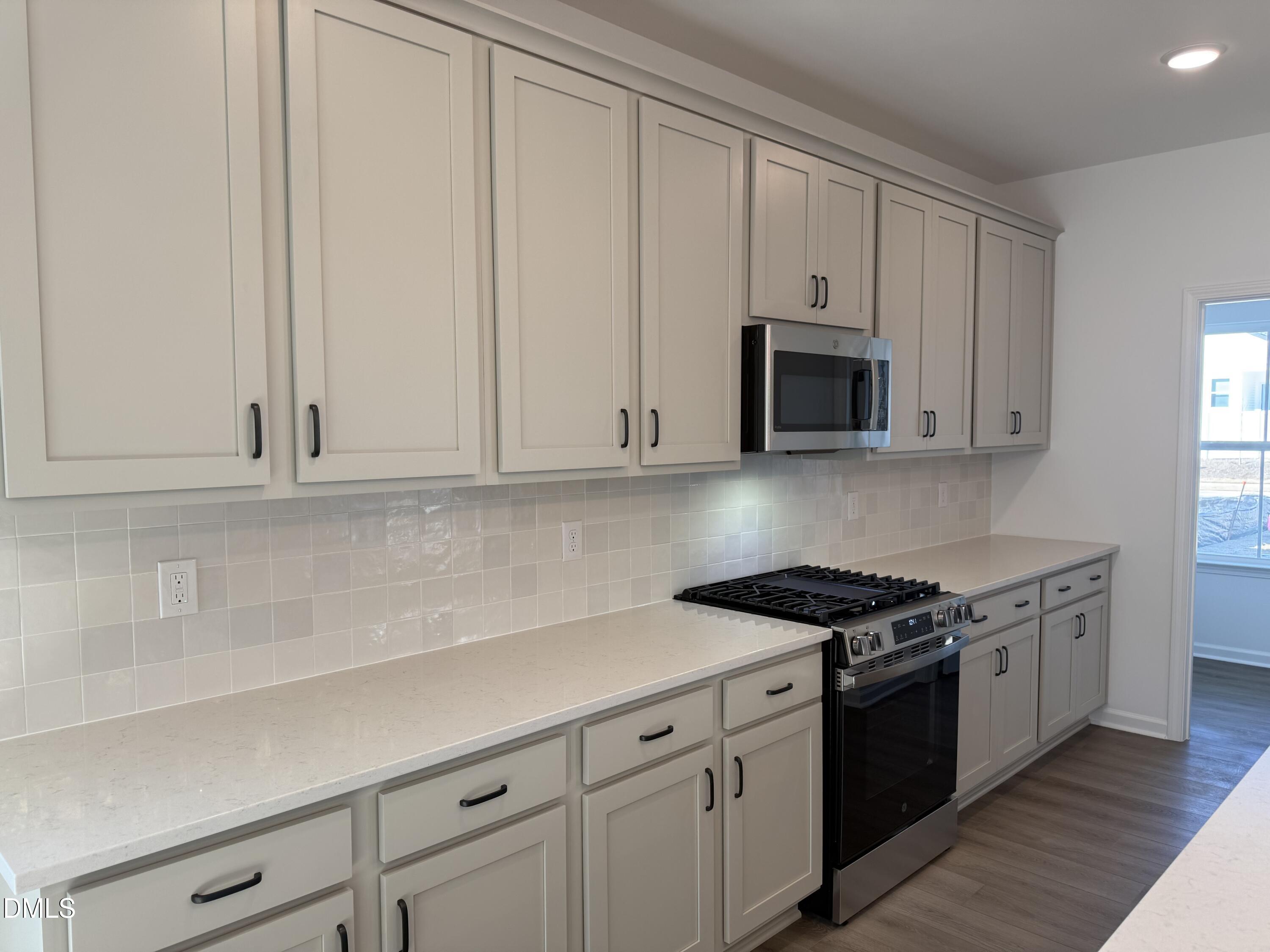 2840 Quarry Road, Unit 174 Rolesville, NC 27571 - Photo 5 of 30 a kitchen with granite countertop white cabinets and stainless steel appliances