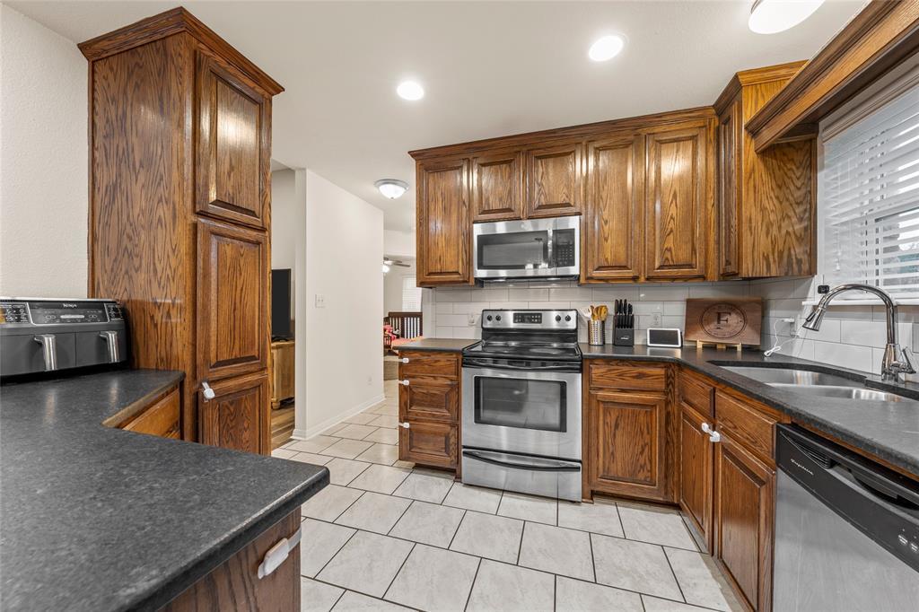 109 Ruby Circle Hewitt, TX 76643 - Photo 5 of 14 a kitchen with stainless steel appliances granite countertop a stove refrigerator sink and cabinets