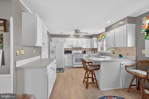 a kitchen with a table chairs refrigerator and cabinets