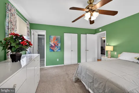 a bedroom with a large bed chandelier and a window