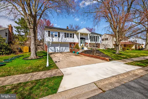 a front view of a residential houses with yard and green space