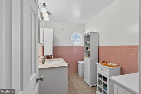 a bathroom with a sink a toilet and mirror