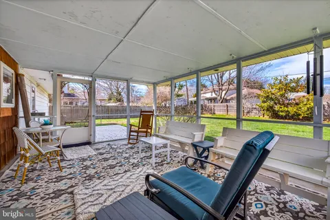 a living room with patio furniture and a floor to ceiling window