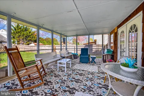 a living room with patio furniture and a floor to ceiling window
