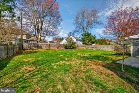 a view of a house with backyard and a tree
