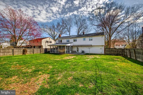 a view of a house with a big yard and large tree