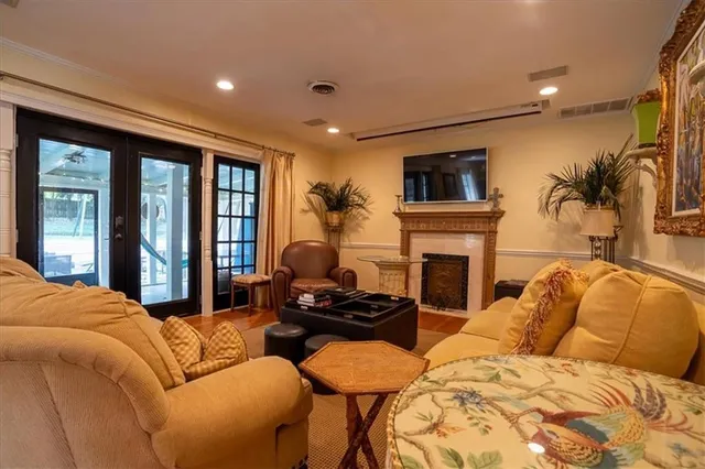 a bedroom with furniture a flat screen tv and a fireplace