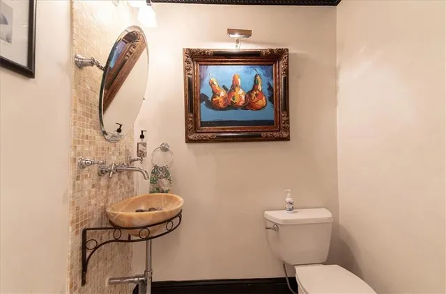 a bathroom with a toilet a sink and a mirror