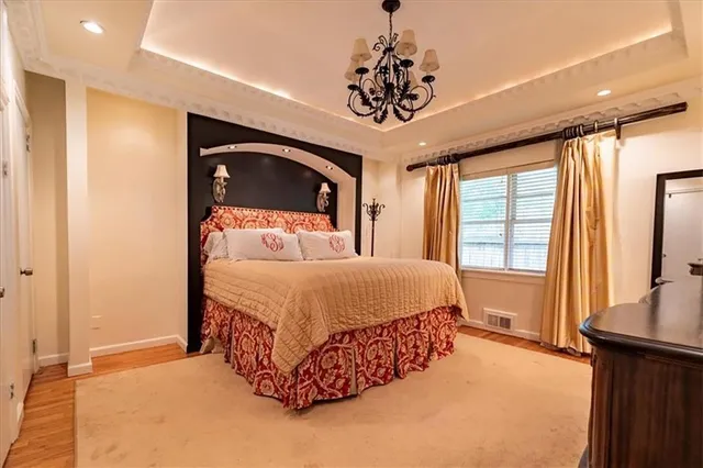 a spacious bedroom with a bed and a chandelier