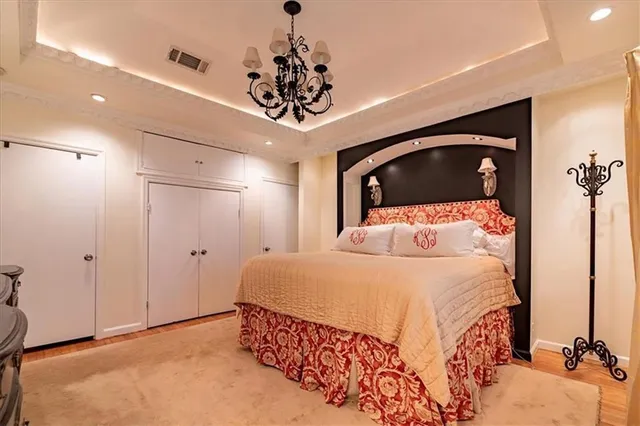 a bedroom with a bed and a chandelier