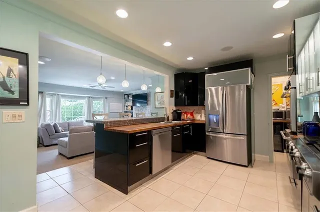 a kitchen with stainless steel appliances granite countertop a refrigerator and a stove top oven