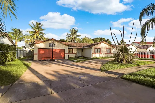 a view of a house with a big yard and large trees