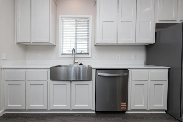 a kitchen with stainless steel appliances granite countertop white cabinets and a stove