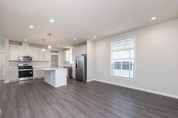 a open kitchen with white cabinets wooden floor and stainless steel appliances