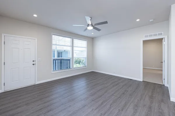 an empty room with closet and fan