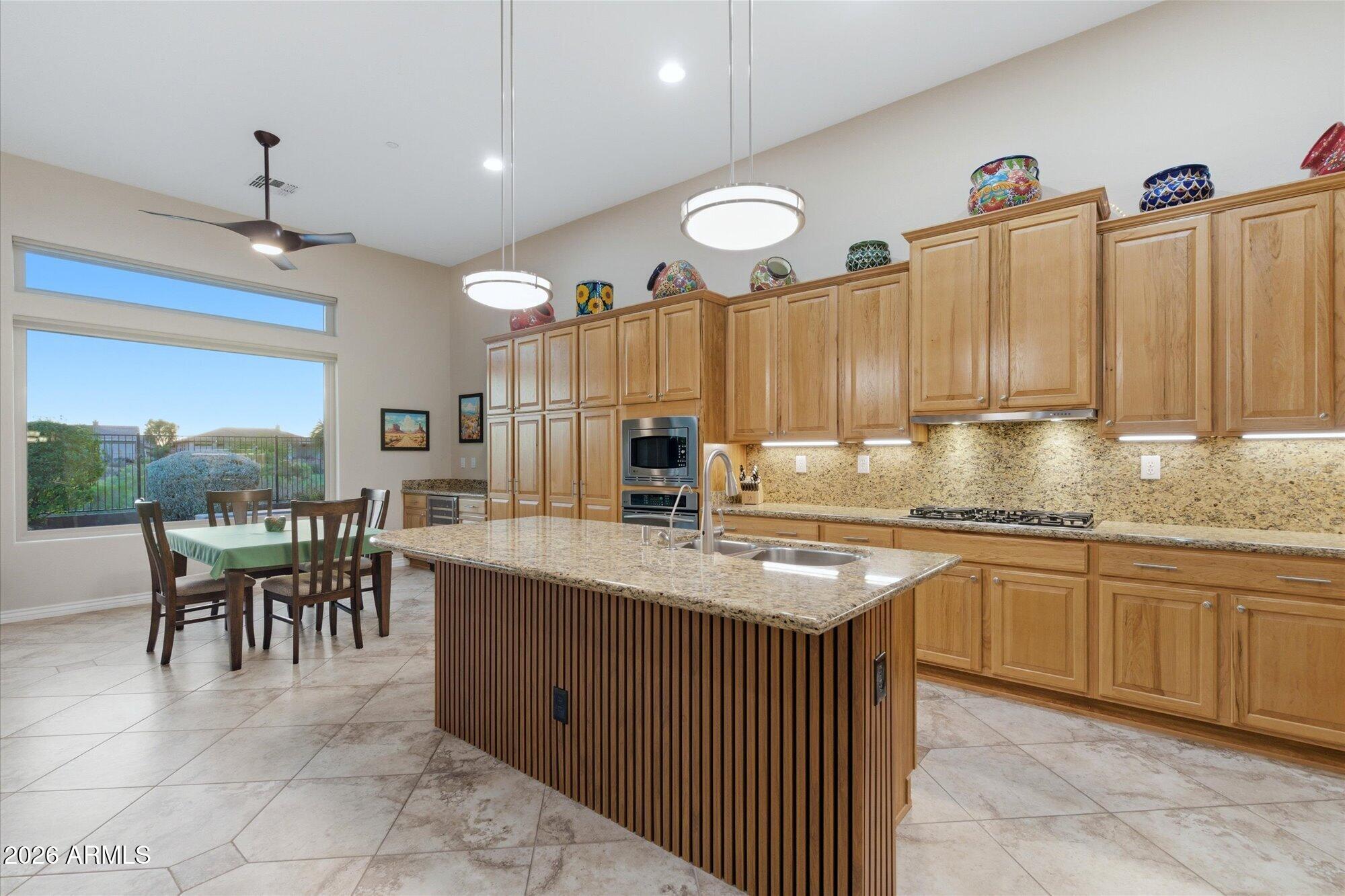 40322 North Hawk Ridge Trail Anthem, AZ 85086 - Photo 20 of 63 a kitchen with kitchen island granite countertop a sink cabinets and stainless steel appliances