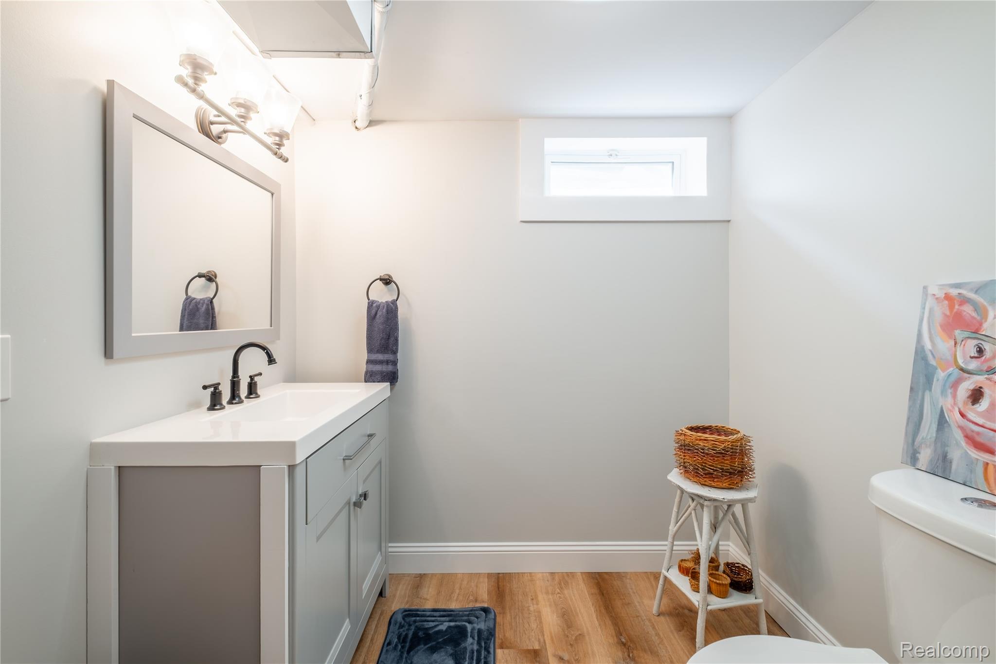 5179 East Baldwin Road Holly, MI 48442 - Photo 18 of 30 Modern bathroom featuring a gray vanity with white quartz countertop, integrated rectangular sink, and matte black faucet