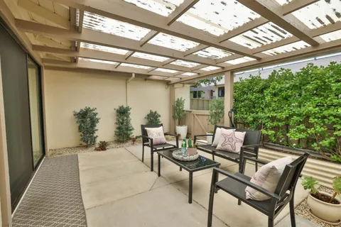a view of a patio with table and chairs and potted plants