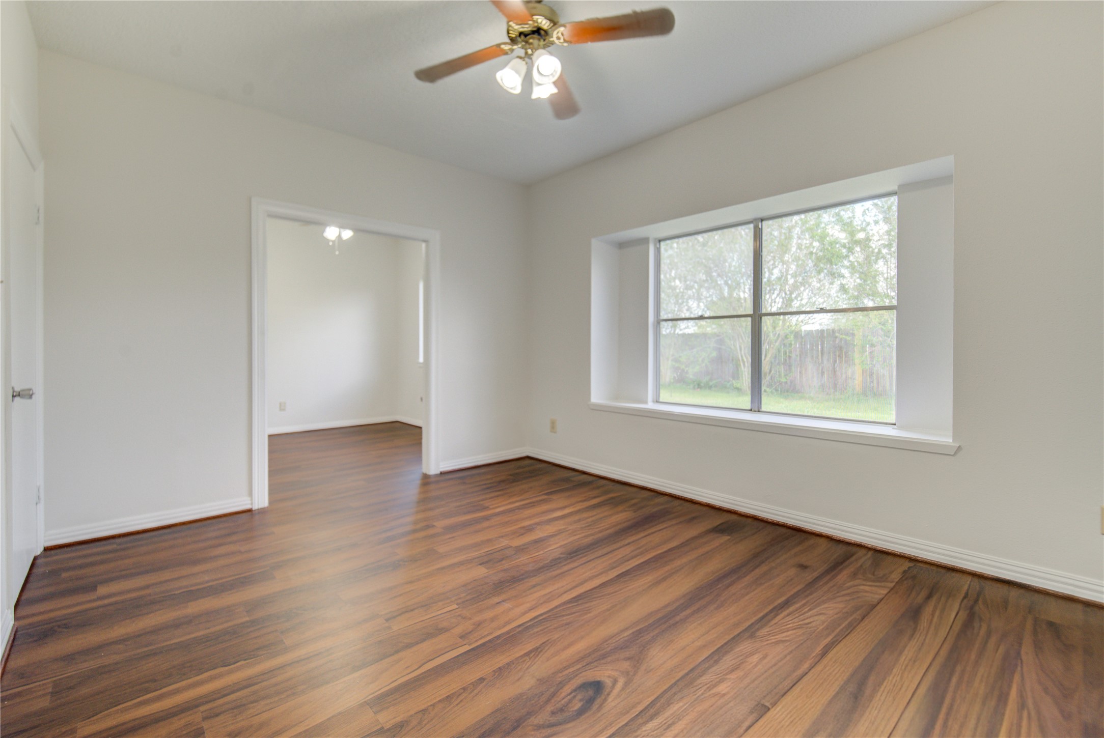 308 North Ranch House Road Angleton, TX 77515 - Photo 19 of 38 Spacious primary bedroom featuring rich wood-style flooring, neutral paint tones, and abundant natural light.