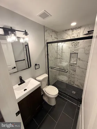 a bathroom with a granite countertop sink toilet and shower