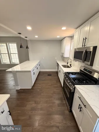 a large kitchen with stainless steel appliances a stove a sink dishwasher and a microwave