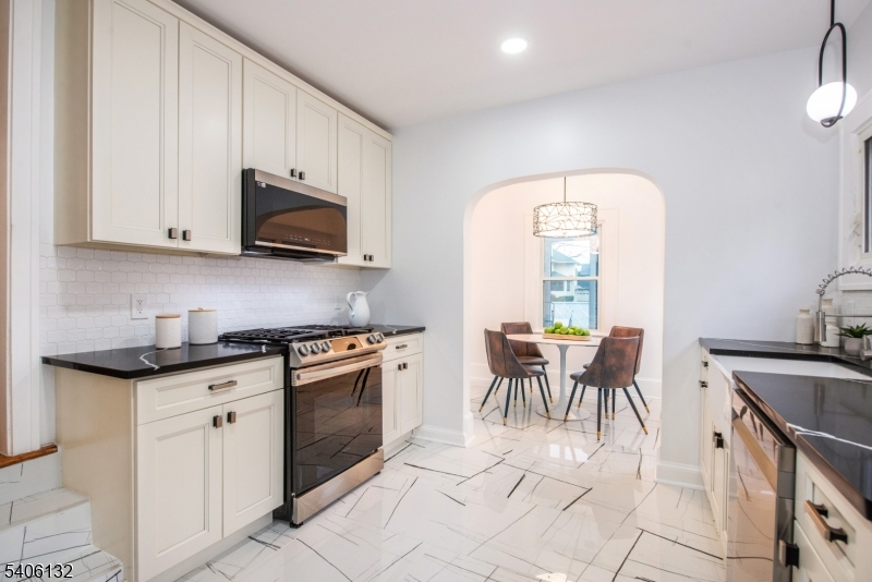 570 Cameron Road South Orange, NJ 07079 - Photo 7 of 34 a kitchen with stainless steel appliances granite countertop a stove a sink a microwave and dining table