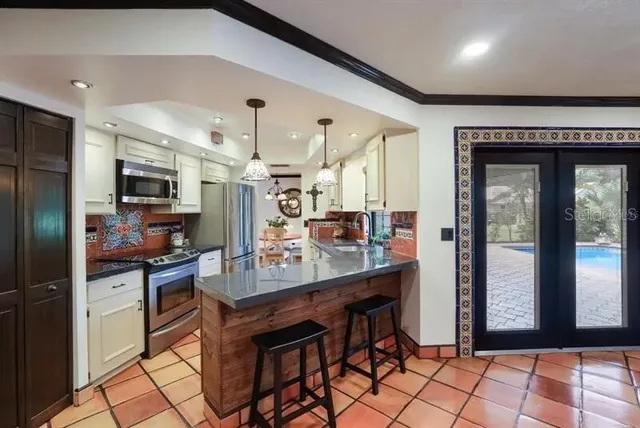 a kitchen with cabinets and chairs
