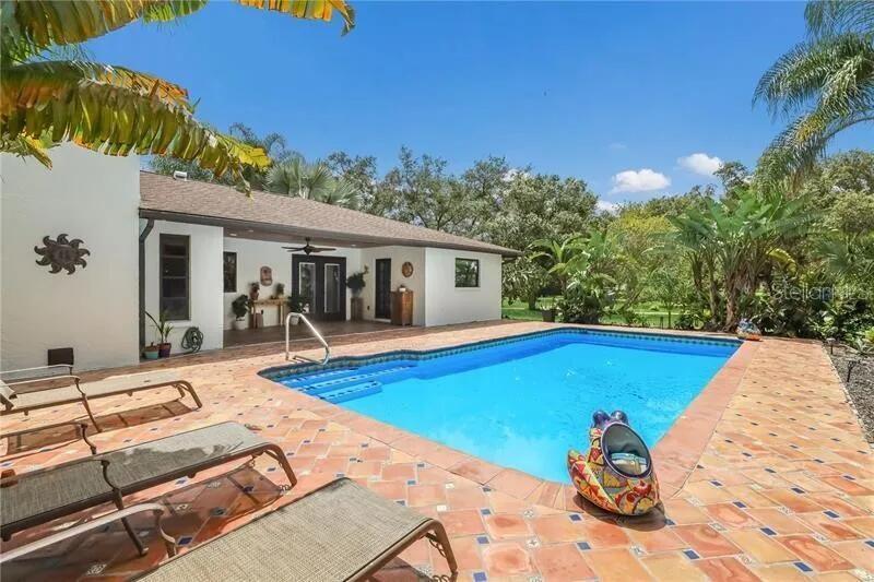 2077 Racimo Drive Sarasota, FL 34240 - Photo 4 of 12 a view of a backyard with a patio and swimming pool