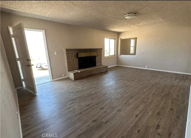 an empty room with wooden floor and fireplace