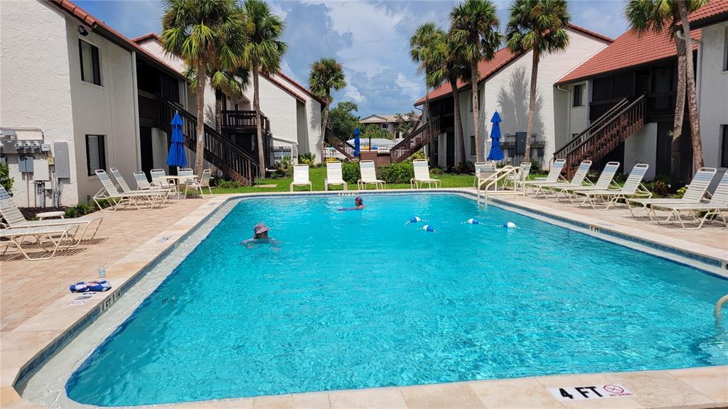1626 Stickney Point Road, Unit 102 Sarasota, FL 34231 - Photo 24 of 42 a swimming pool with outdoor seating and yard