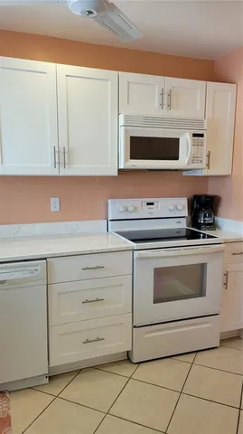 a kitchen with granite countertop white cabinets stainless steel appliances and a sink