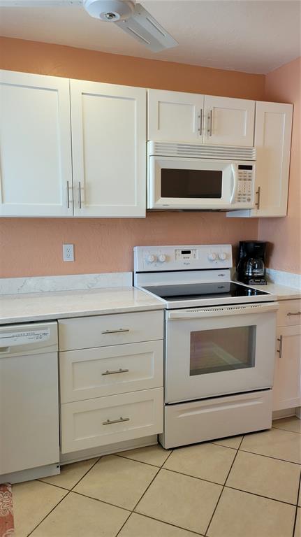 1626 Stickney Point Road, Unit 102 Sarasota, FL 34231 - Photo 3 of 42 a kitchen with granite countertop white cabinets stainless steel appliances and a sink