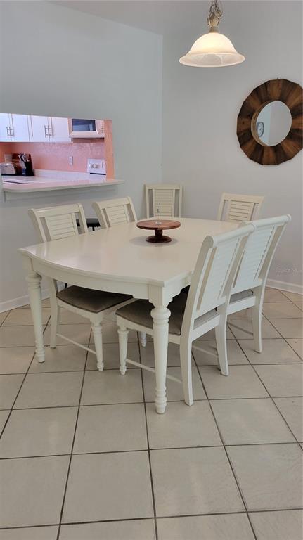 1626 Stickney Point Road, Unit 102 Sarasota, FL 34231 - Photo 8 of 42 a dining room with furniture and chandelier