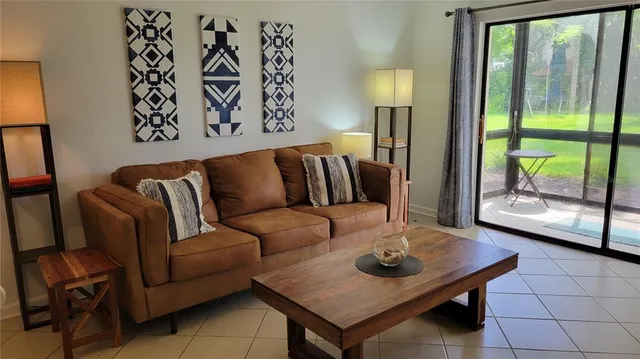 a living room with furniture and a floor to ceiling window