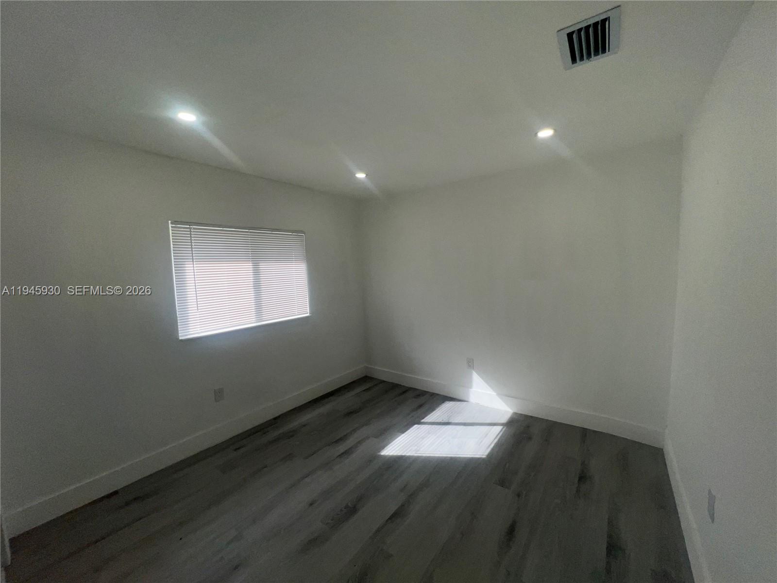 1800 Southwest 3rd Street, Unit D Miami, FL 33135 - Photo 16 of 27 an empty room with wooden floor and windows