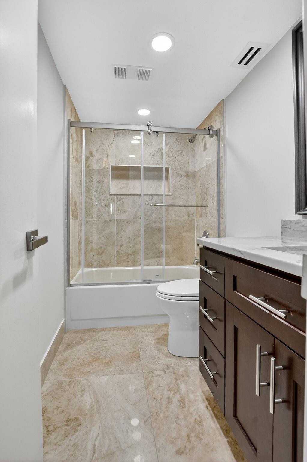 7145 Promenade Drive, Unit C702 Boca Raton, FL 33433 - Photo 44 of 82 a bathroom with a granite countertop sink a toilet and shower