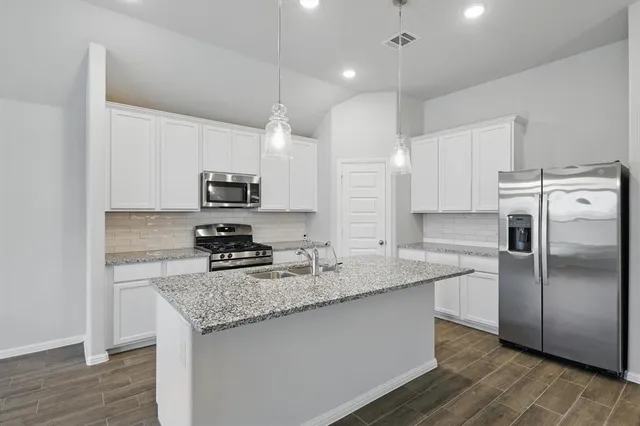 a large kitchen with kitchen island a island a sink stainless steel appliances and cabinets