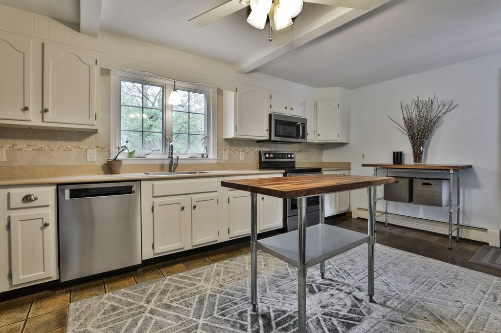 75 Langen Road Lancaster, MA 01523 - Photo 3 of 42 a kitchen with stainless steel appliances a stove a sink a microwave a dining table and chairs