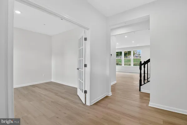 a view of a hallway with wooden floor and entryway