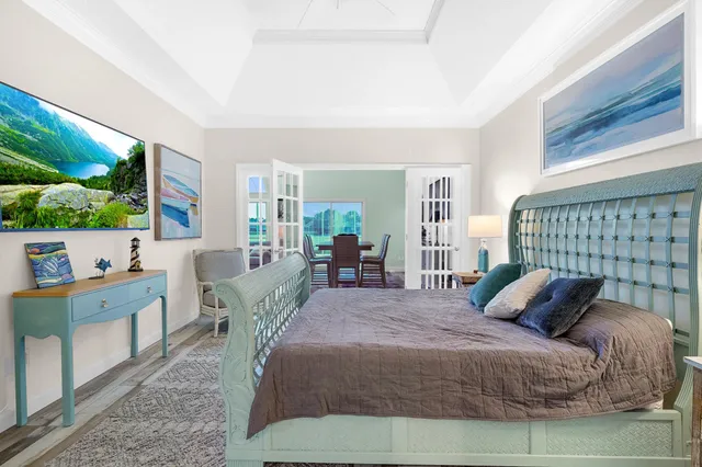 a bedroom with a bed and large windows