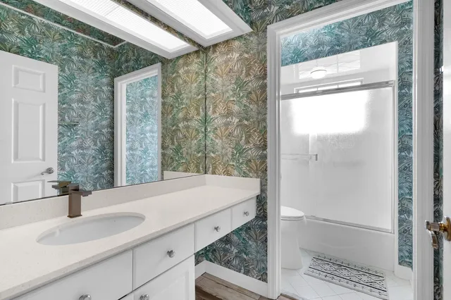 a bathroom with a granite countertop sink and a mirror