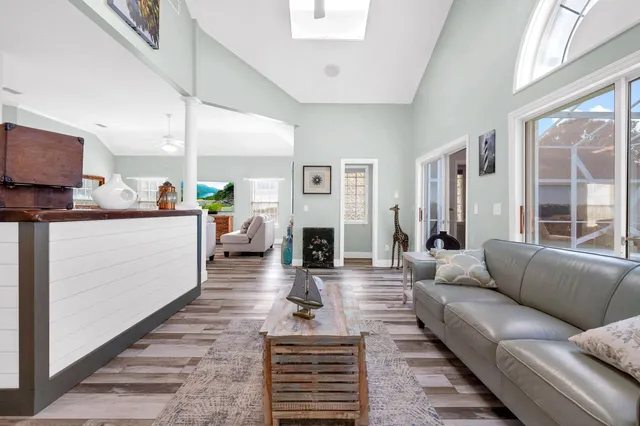 a living room with furniture a fireplace and a large window